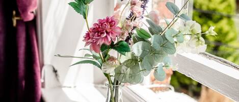 A clear view of a window with a vase of flowers on the sill.