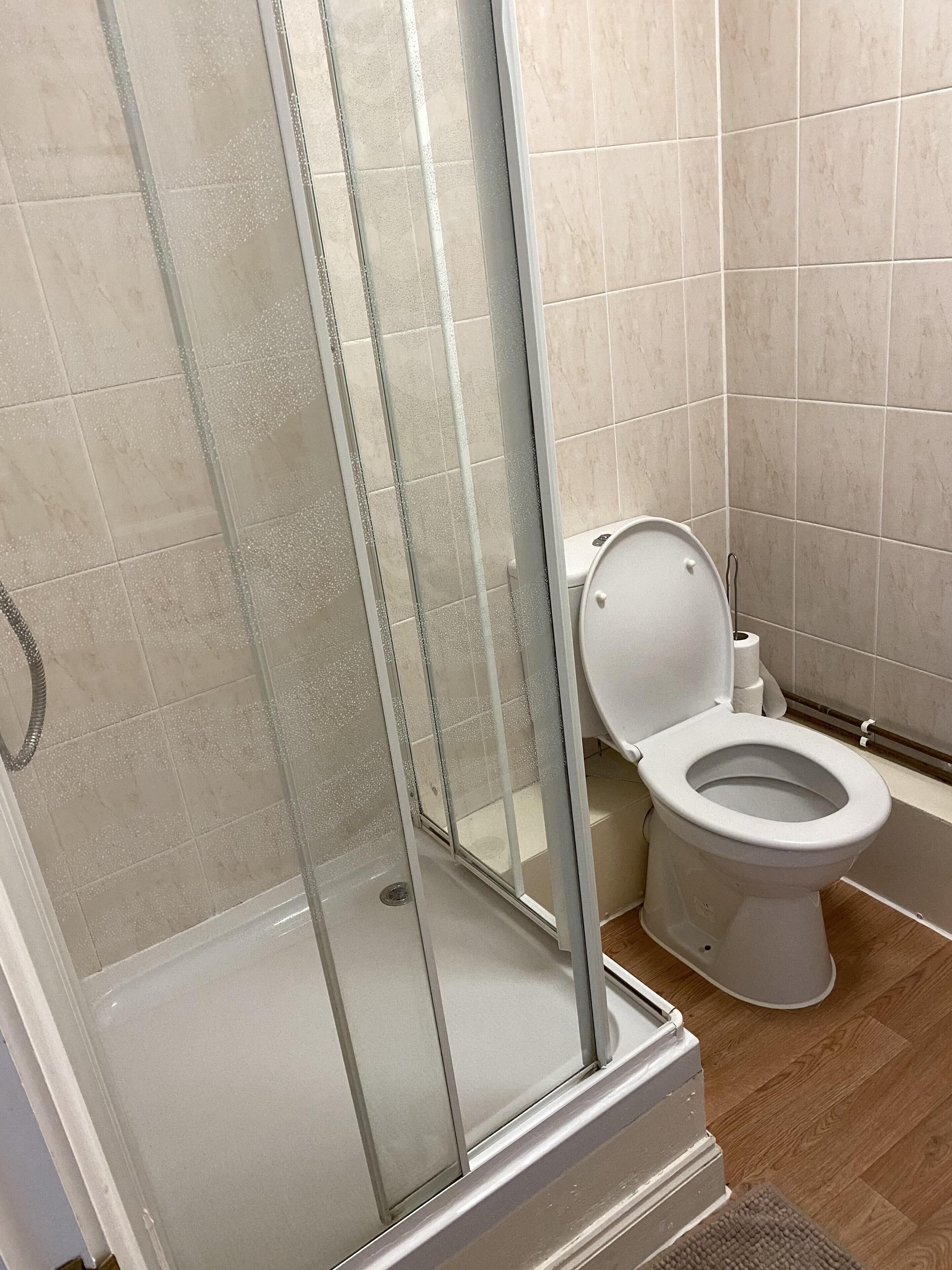 A bathroom with a glass-enclosed shower, a toilet, and a bathtub.