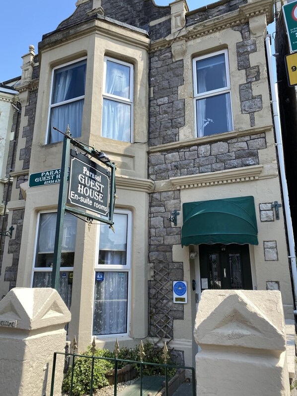 A traditional building with a sign for 'Parasol Guest House' indicating a guest house with en-suite rooms. - The Parasol Weston (Weston-super-Mare)
