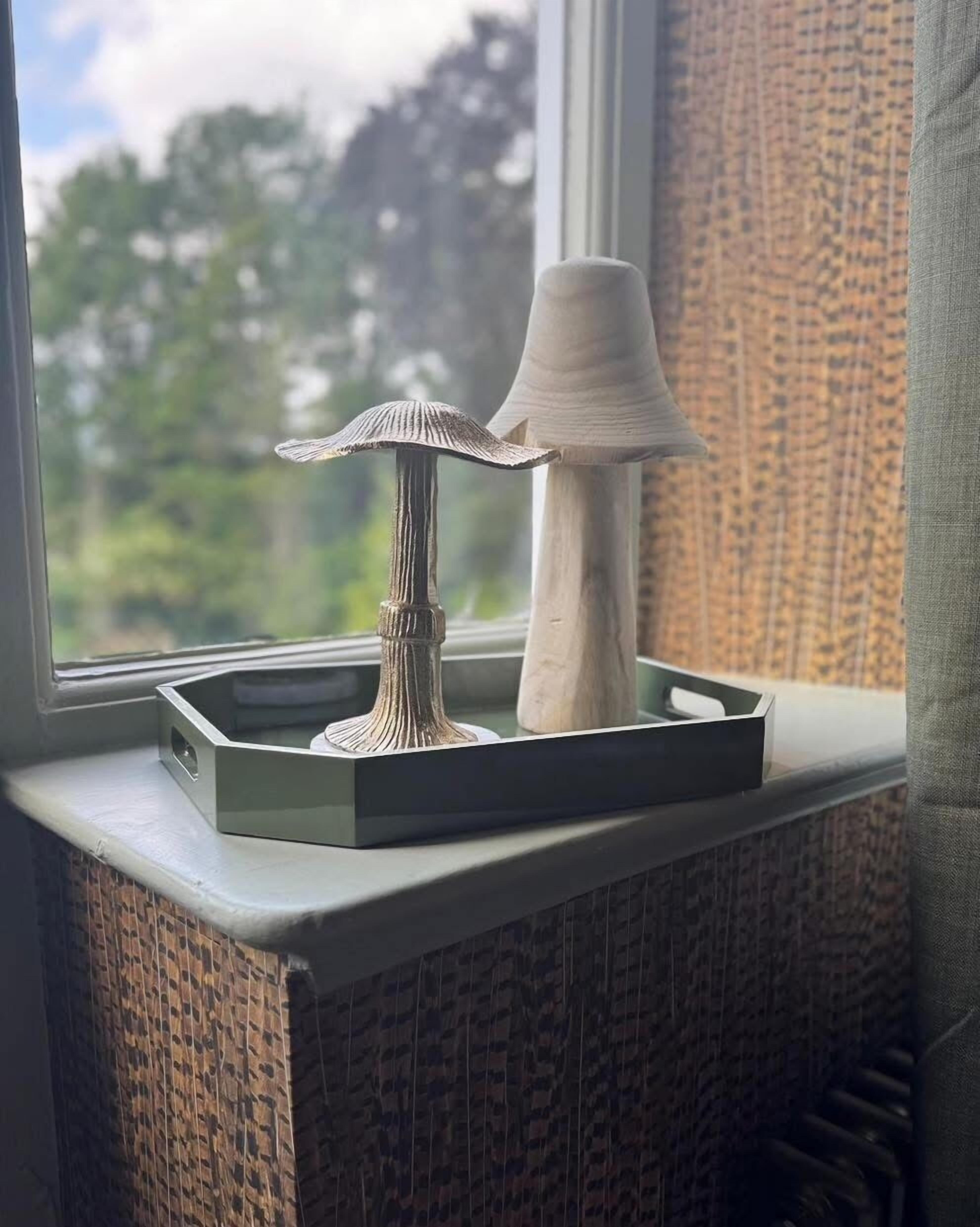 A window sill with a decorative lamp and a small table.