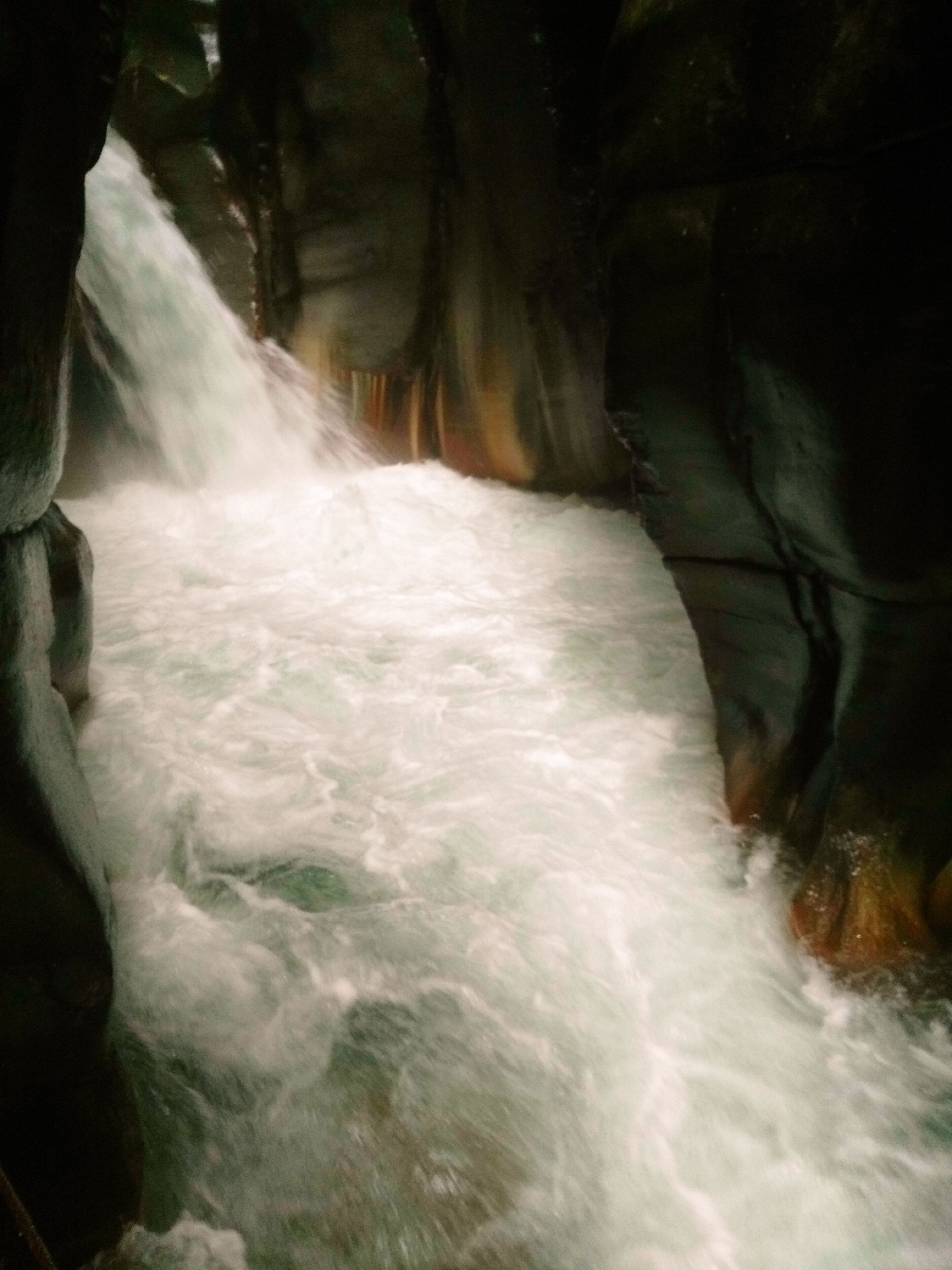 A waterfall flowing through a rocky cave.