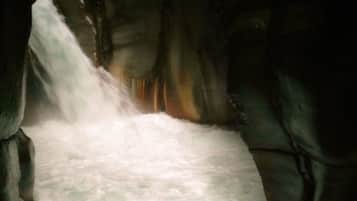 A waterfall flowing through a rocky cave.