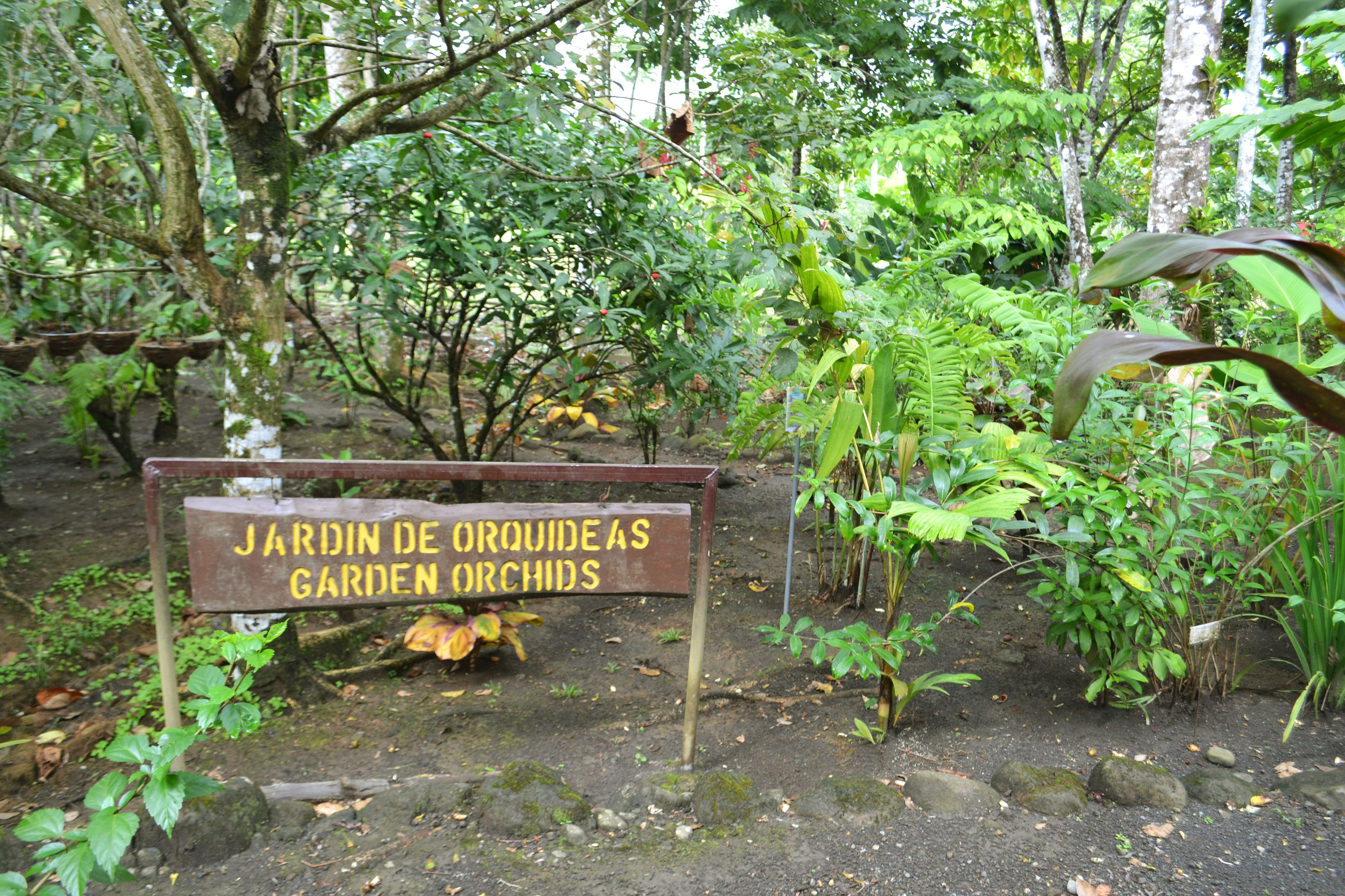 Letrero en un jardín que dice 'Jardín de Orquídeas Garden Orchids'.