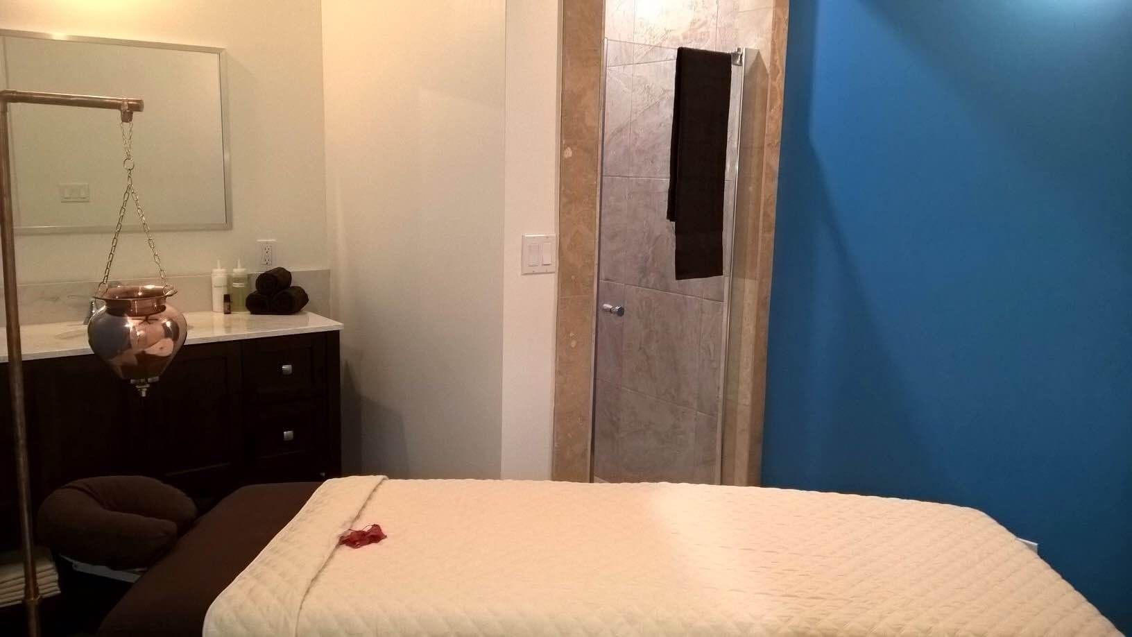 Ein Schlafzimmer mit einem Bett, einem Schminktisch, einem Spiegel und einer Tür mit einem Loch.