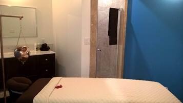 Ein Schlafzimmer mit einem Bett, einem Schminktisch, einem Spiegel und einer Tür mit einem Loch.