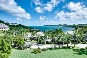 A coastal residential area with houses, palm trees, and a clear view of the ocean. - Residences at Nonsuch Bay Antigua (Freetown)