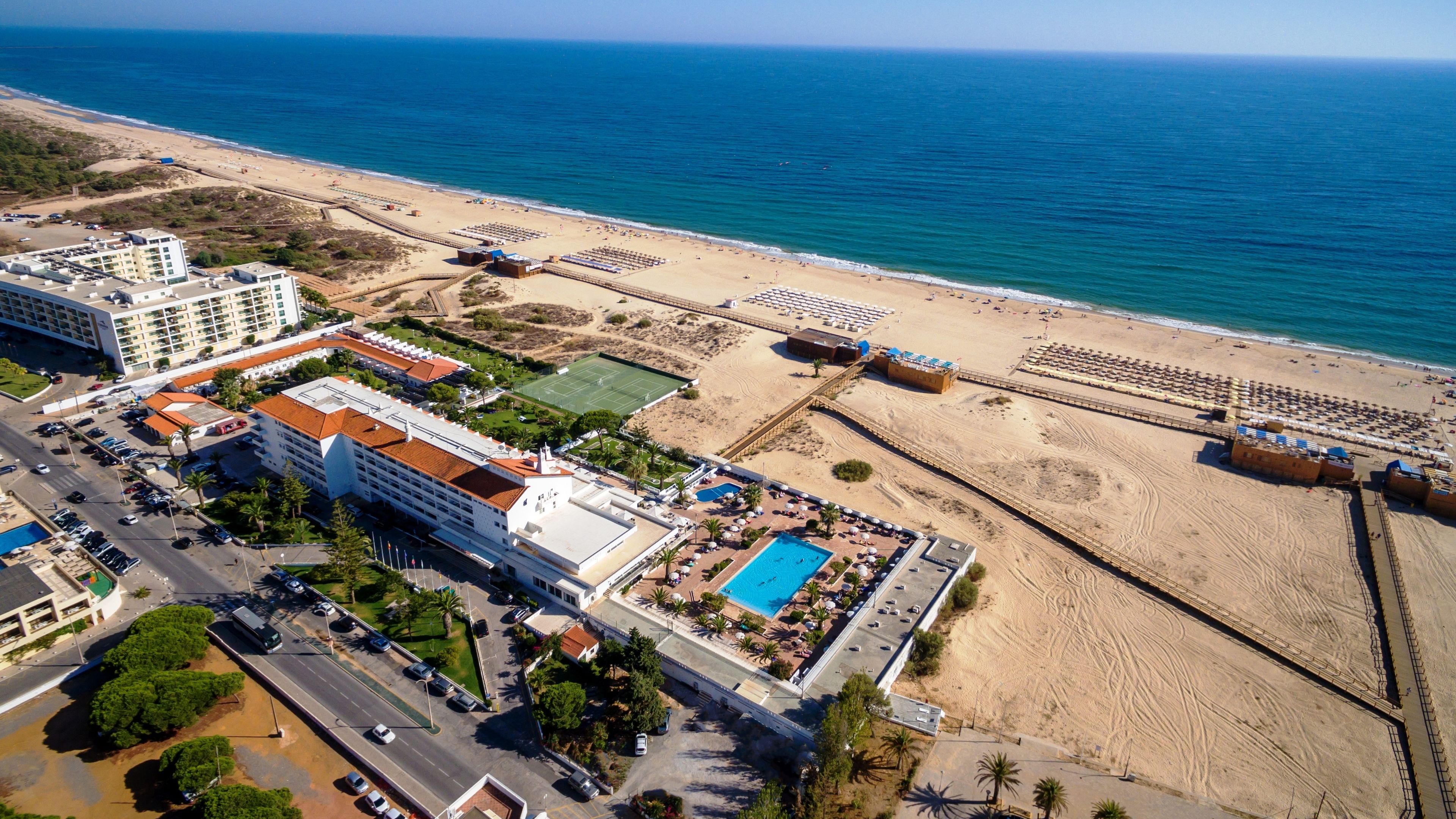 En la playa, playa de arena blanca, camastros y sombrillas 
