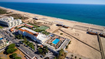En la playa, playa de arena blanca, camastros y sombrillas