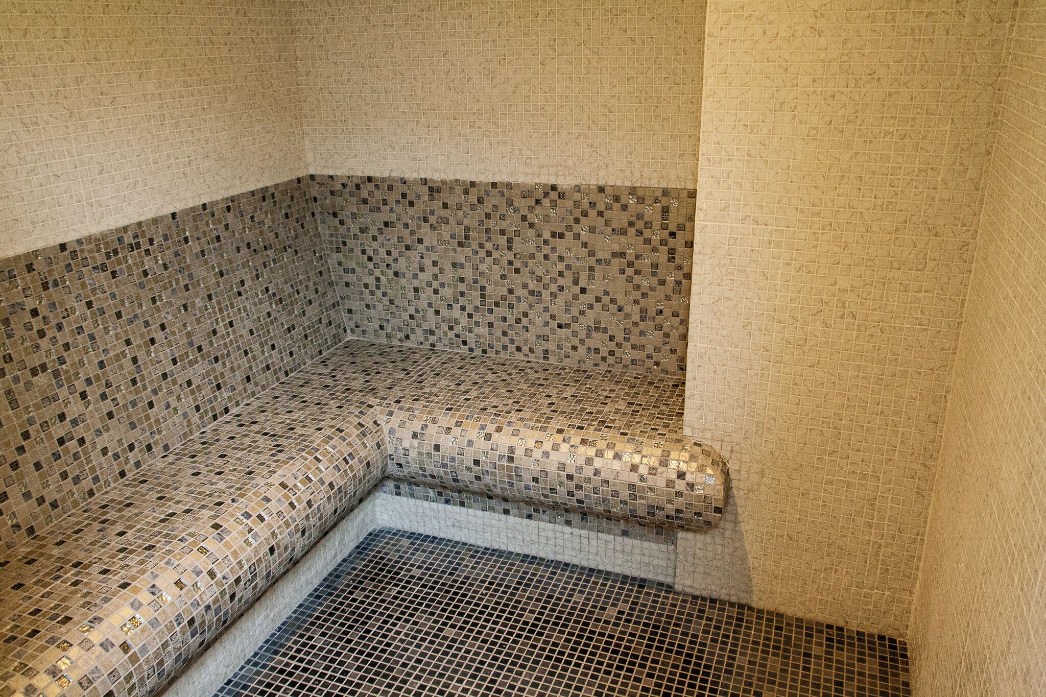 Canto de um quarto com piso e paredes estampadas, e uma parede texturizada.