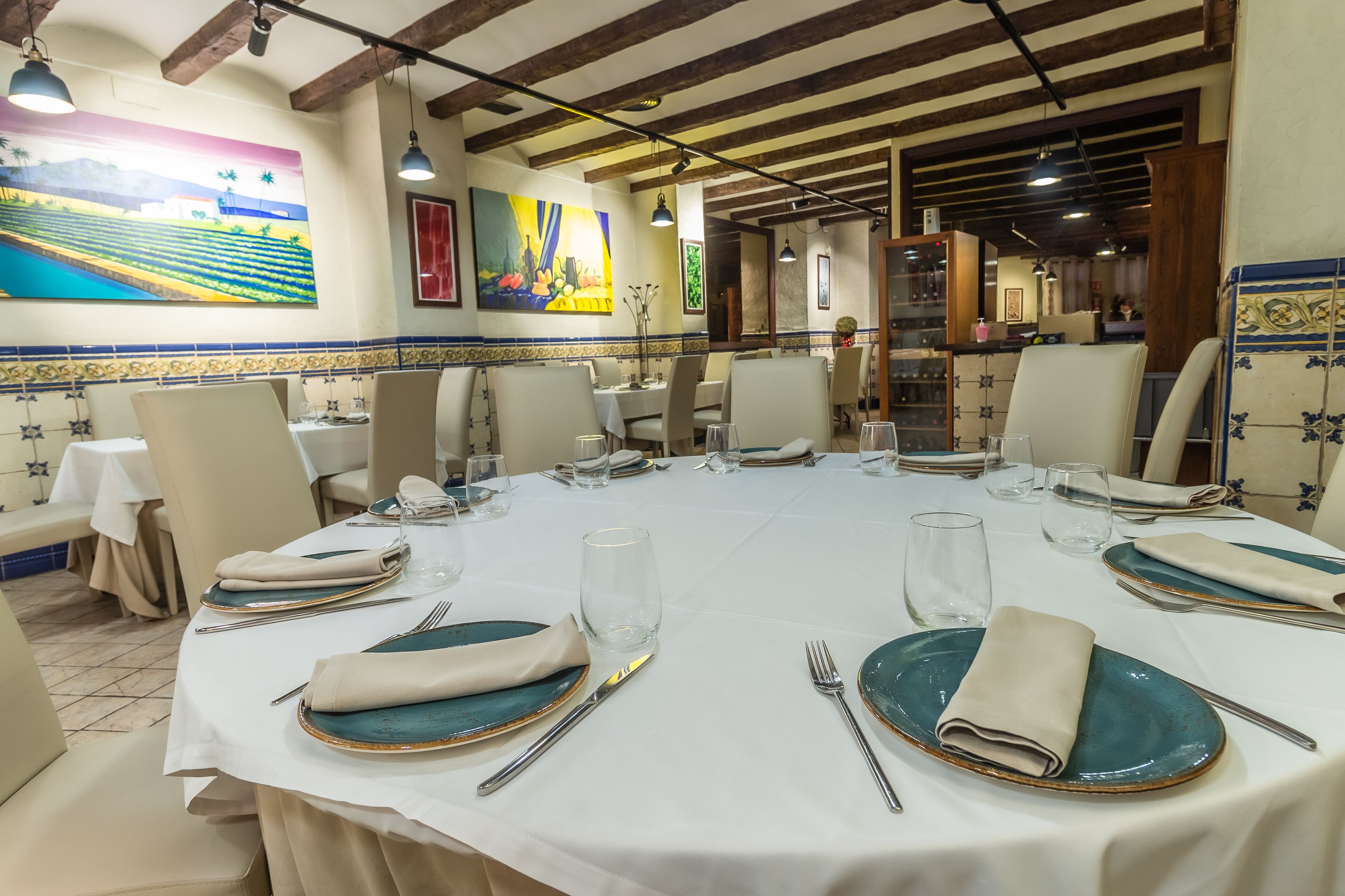Un comedor con manteles blancos, mesas dispuestas con cuidado y sillas.