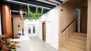 A modern reception area with a wooden desk, a computer, and a sign reading "PACOCHE MURCIA". - Hotel Pacoche Murcia (Murcia)