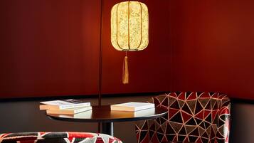 Una habitación con una mesa redonda, una silla estampada y una lámpara colgante.