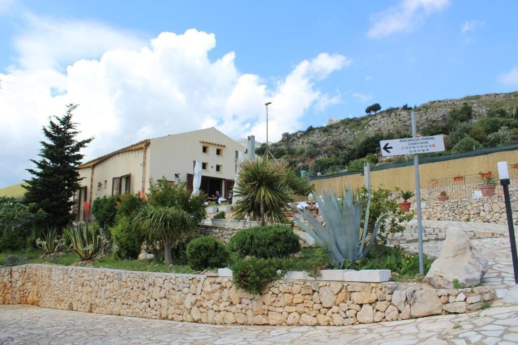 A building with a stone wall and a sign indicating parking.