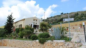 A building with a stone wall and a sign indicating parking.