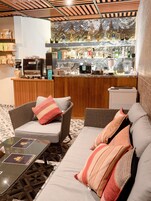 A cozy seating area with wicker furniture and a coffee machine.
