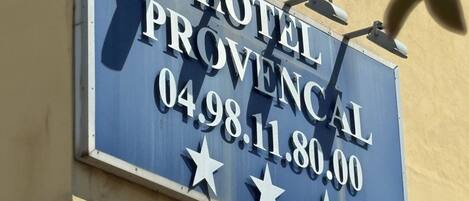 Een hotelschild met de naam 'HOTEL PROVENCAL' en telefoonnummer '0498.11.80.00'.