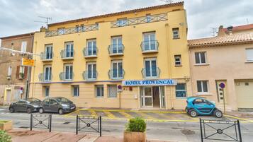 Um edifício amarelo com uma placa que diz 'HOTEL PROVENCAL'.