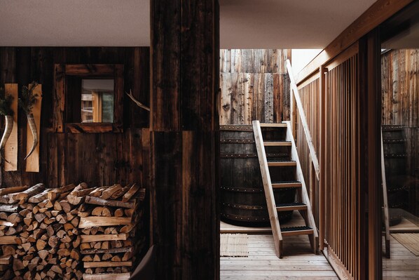 A rustic wooden interior with a wooden staircase leading to a loft area. - Lagació Hotel Mountain Residence (Badia)