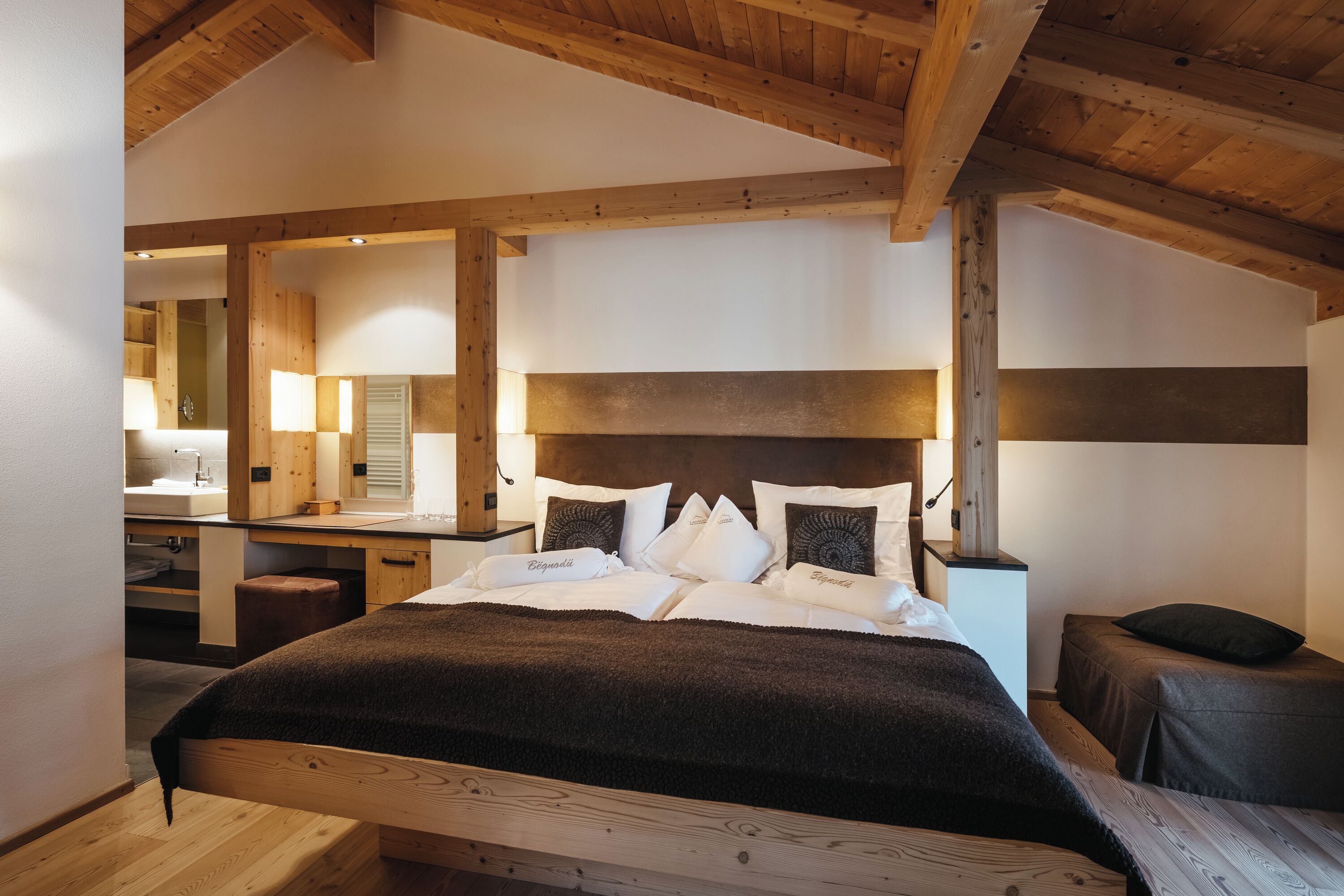 Un dormitorio con una cama de madera, una mesita de noche y un espejo.