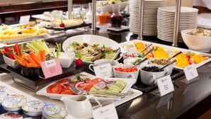 A buffet with various food items and utensils. - Warmiński Hotel & Conference (Olsztyn)
