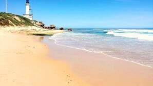 A beach with a lighthouse, sandy shore, and ocean waves. - Point Lonsdale Guest House (Point Lonsdale)