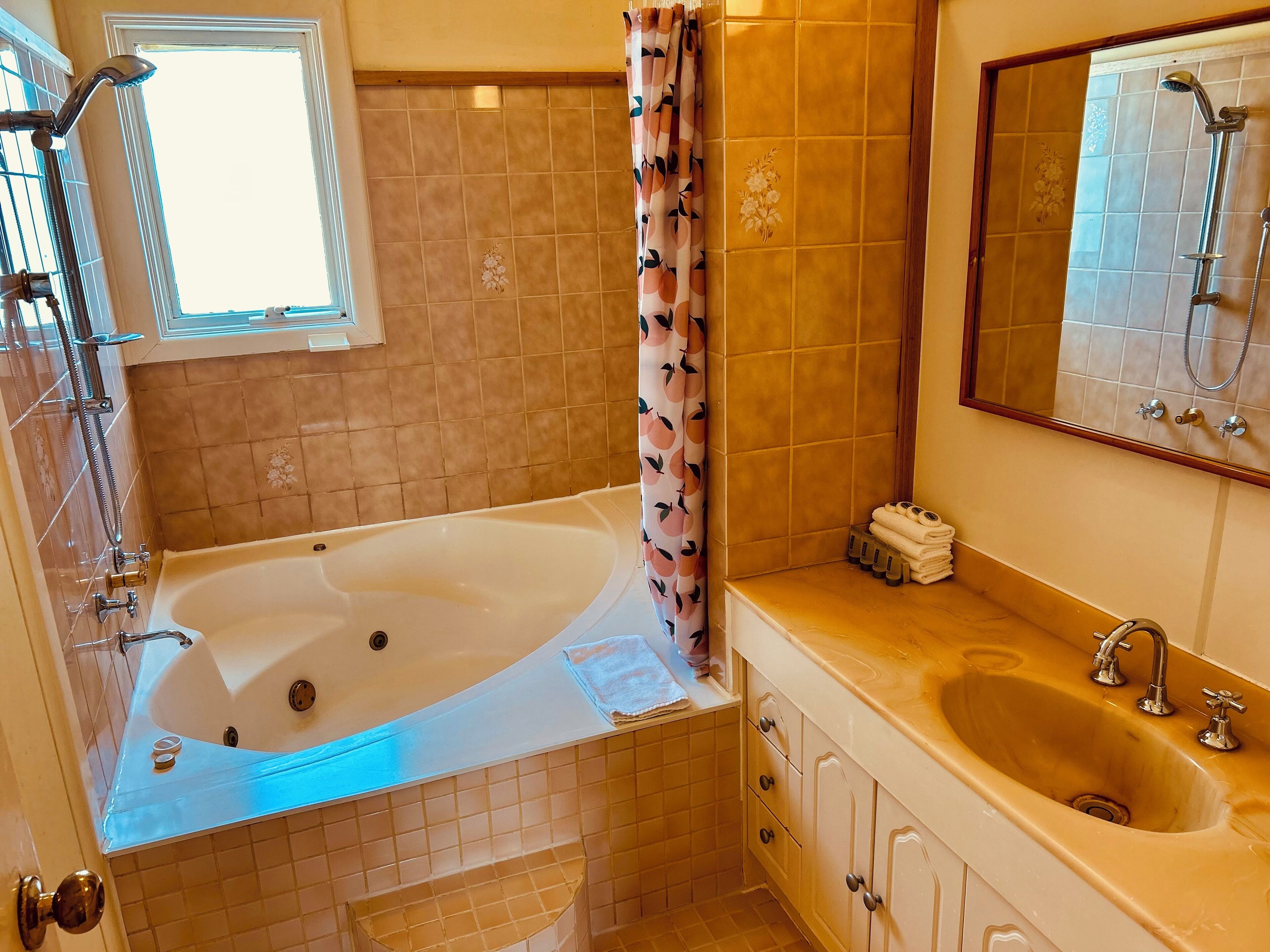 A bathroom with a bathtub, a sink, and a shower area.