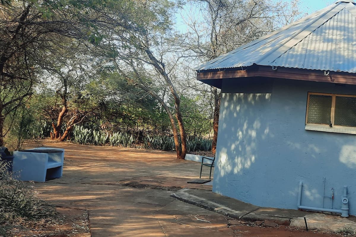 Un petit bâtiment d’un seul étage, doté d’un toit en tôle ondulée et d’une fenêtre.