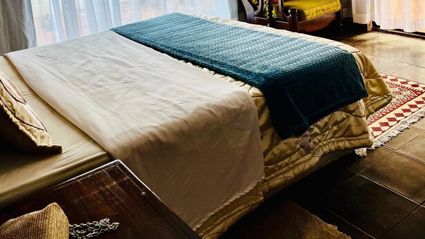 A hotel room with a bed, a chair, and a table. - Copacopa Lodge and Conference Centre (Thulamela)