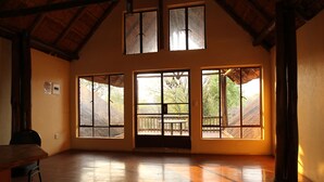 A spacious room with wooden floors, large windows, and a high ceiling. - Copacopa Lodge and Conference Centre (Thulamela)