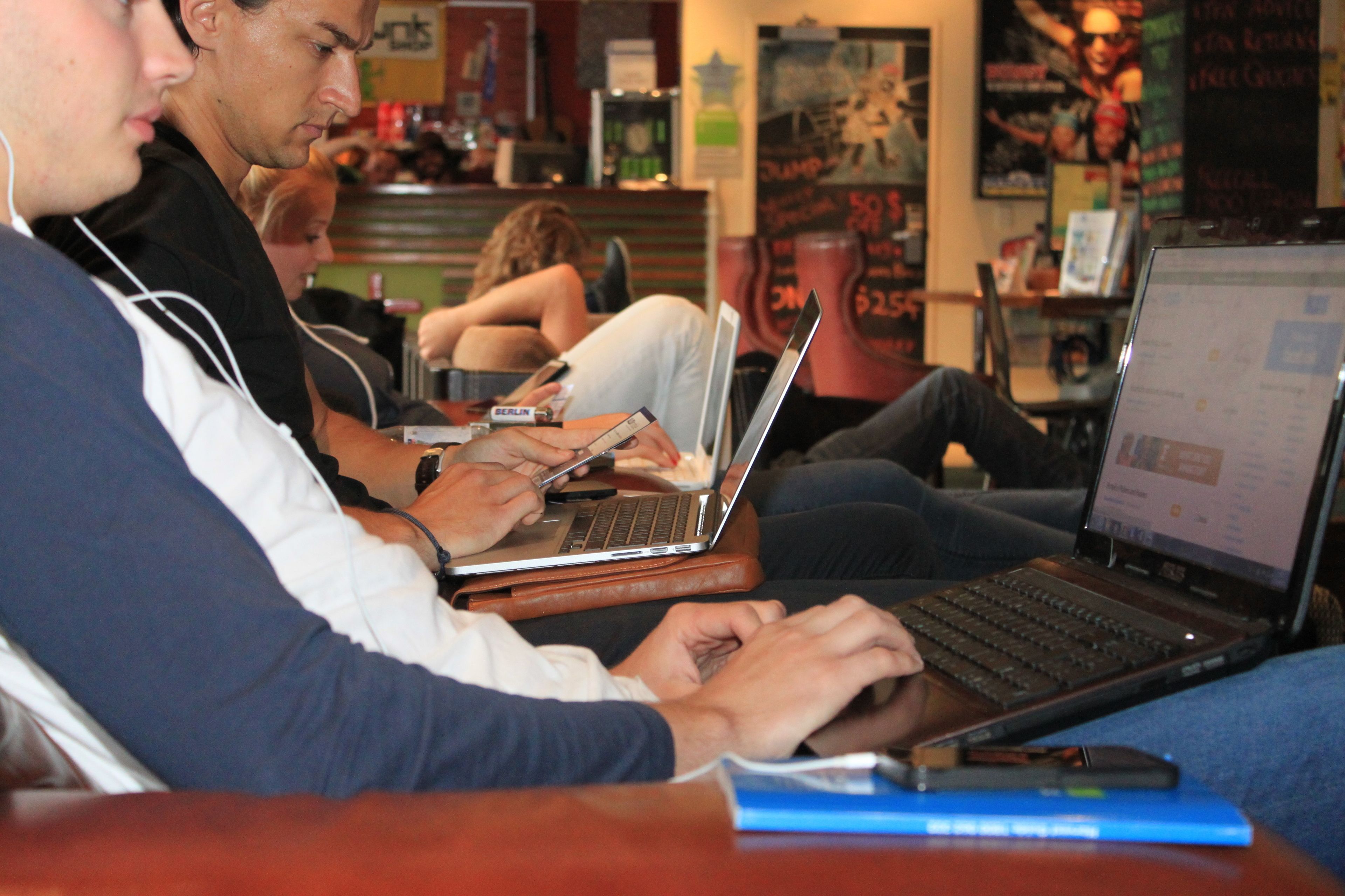 A person using a laptop at a table in a public space.