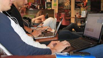 A person using a laptop at a table in a public space.