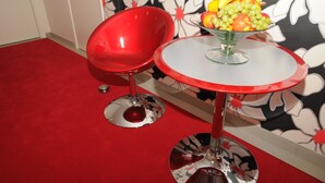 A red chair and a table with a fruit bowl. - Hotel Coco Aps (Esbjerg)