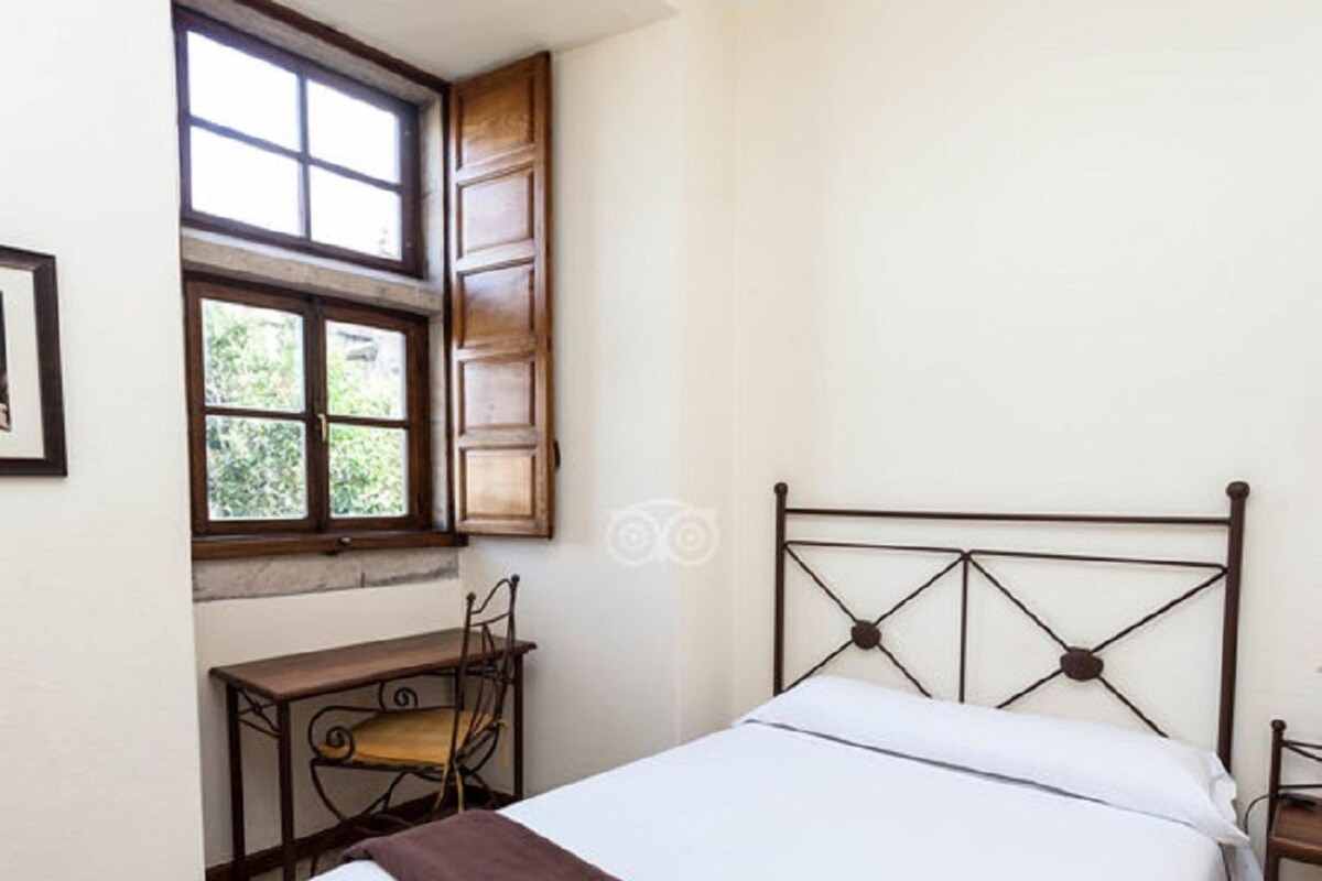 Ein Schlafzimmer mit einem Bett, einem Schreibtisch und einem Stuhl.