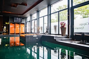 Una piscina techada, sillones reclinables de piscina