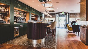 A bar area with a counter, stools, and a patterned rug.