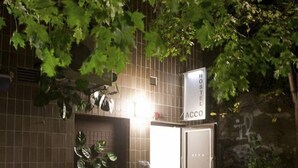A hostel with a tiled exterior, a sign indicating it's a hostel, and a door leading to the interior. - Acco Hostel (Stockholm)