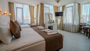 A hotel room with two beds, a desk with a TV, and a chair. - Sultanahmet Cesme Hotel (Istanbul)