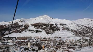 A snow-covered mountain town with buildings and a ski lift.