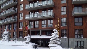 A multi-story hotel with balconies, a sign reading "Ristorante Bar Ristorante", and snow-covered trees in front. - Hotel Cristallo (Sestriere)