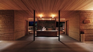 A spacious lobby with wooden paneling, a reception desk, and a seating area. - Six Senses Con Dao (Ho Chi Minh City)