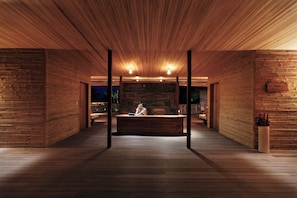 A spacious lobby with wooden paneling, a reception desk, and a seating area. - Six Senses Con Dao (Ho Chi Minh City)