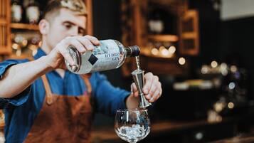 A person pouring a clear liquid from a bottle into a glass.