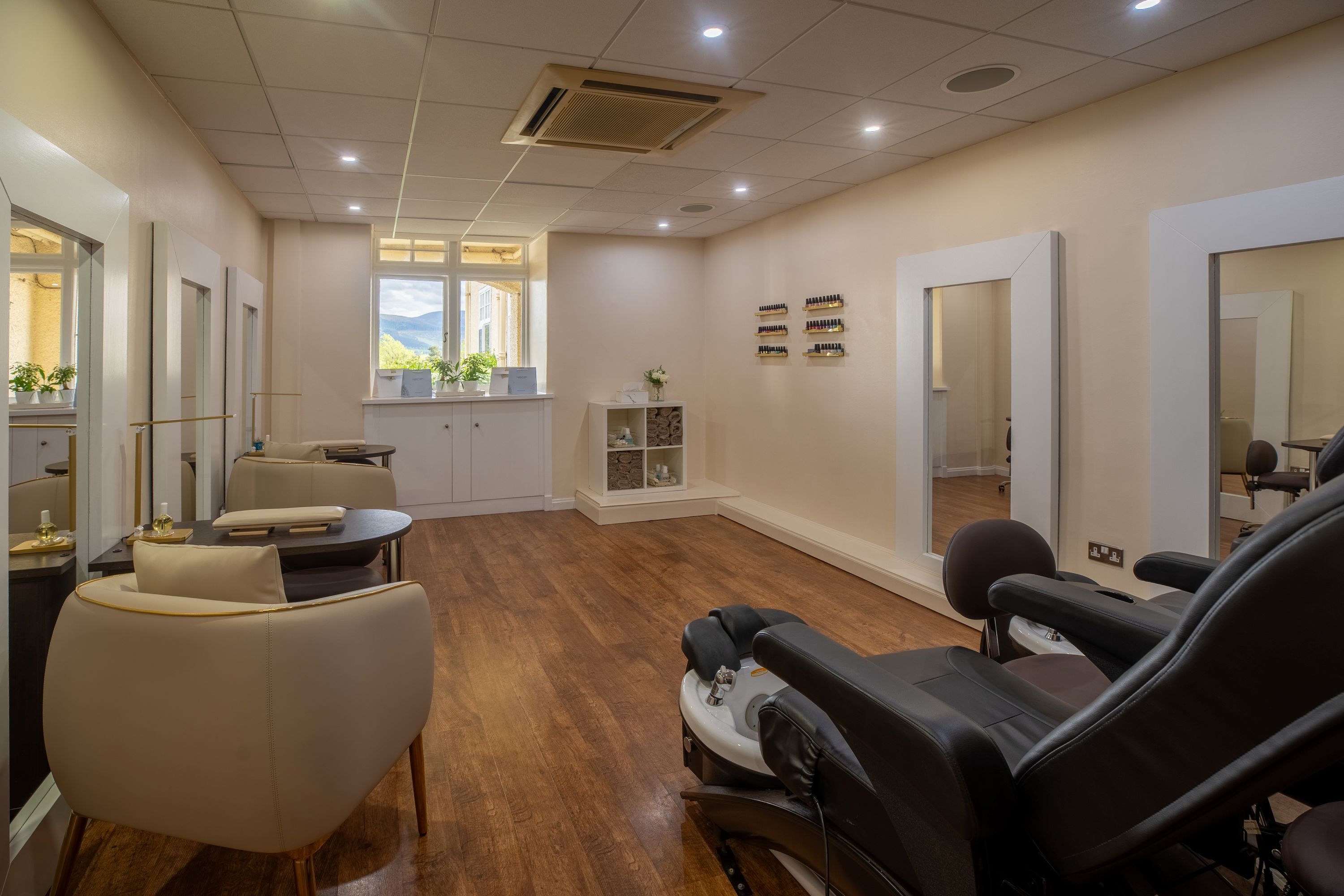 A modern interior with a reception desk, seating area, and a large mirror.