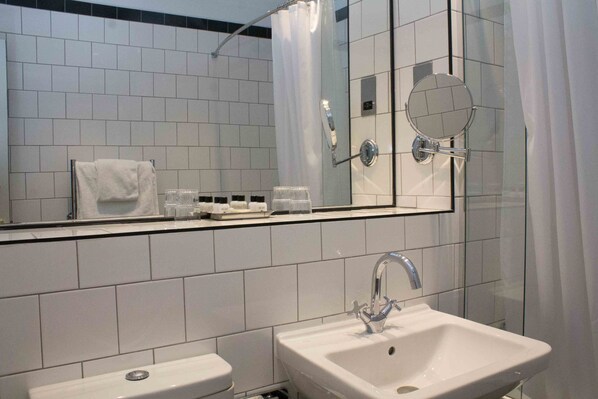 A modern bathroom with a white sink, a mirror, and a glass shower enclosure. - Peebles Hydro Hotel (Peebles)