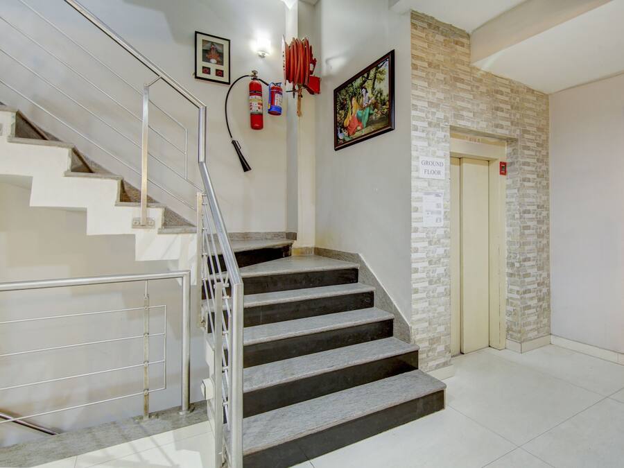A staircase leading to a ground floor with a fire extinguisher and a sign indicating a ground floor.
