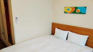 A neatly made bed with white linens, a wooden headboard, and a colorful abstract artwork on the wall. - Comfort Inn Fukushima Nishi Inter (Fukushima)