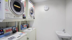 A laundry area with two washing machines, a control panel, and a sink. - Comfort Inn Kumamoto Miyukifueda (Kumamoto)