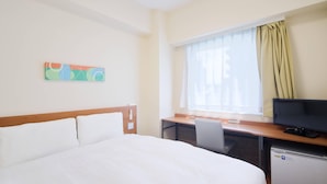 A hotel room with a bed, a desk with a computer, a television, and a small refrigerator. - Comfort Inn Kumamoto Miyukifueda (Kumamoto)