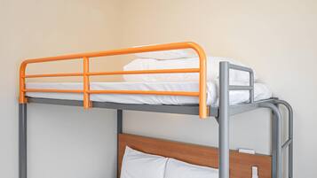 A bunk bed with an orange frame and a wooden headboard.