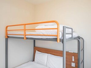 A bunk bed with an orange frame and a wooden headboard. - Comfort Inn Niigata Chuo Inter (Niigata)